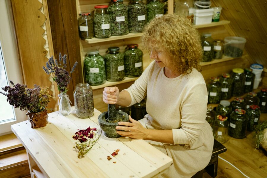 Woman pounding Herbs in mortar with pestle